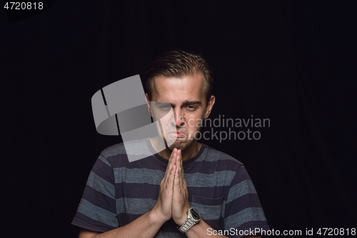 Image of Close up portrait of young man isolated on black studio background