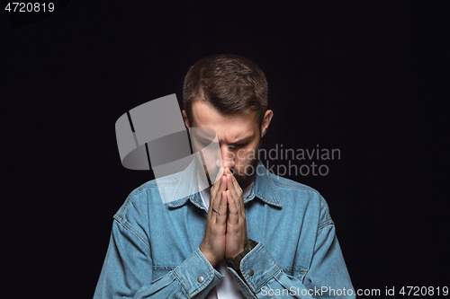 Image of Close up portrait of young man isolated on black studio background