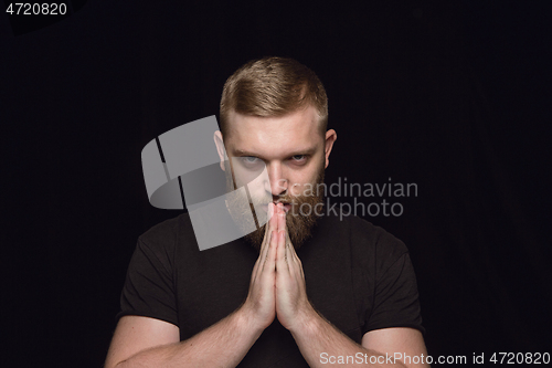 Image of Close up portrait of young man isolated on black studio background