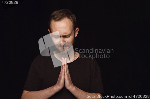 Image of Close up portrait of young man isolated on black studio background