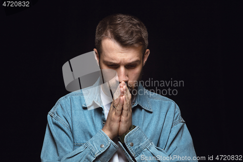 Image of Close up portrait of young man isolated on black studio background