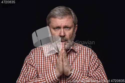 Image of Close up portrait of senior man isolated on black studio background