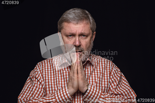 Image of Close up portrait of senior man isolated on black studio background