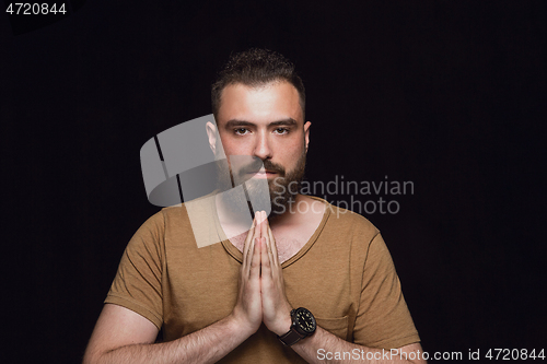 Image of Close up portrait of young man isolated on black studio background