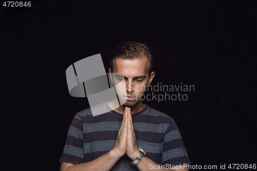 Image of Close up portrait of young man isolated on black studio background