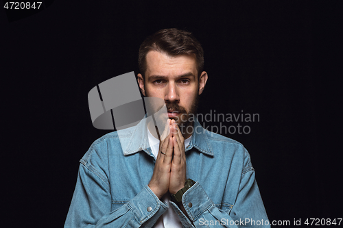 Image of Close up portrait of young man isolated on black studio background