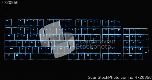 Image of Illuminated keyboard glowing with RGB colors in the dark