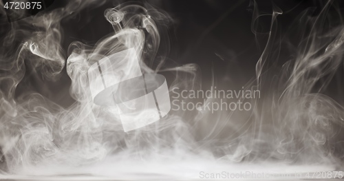 Image of Smoke cloud whirling against dark background slow motion footage