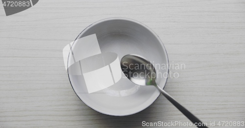 Image of Clean bowl without food dropping spoon into it in slow motion from 120fps