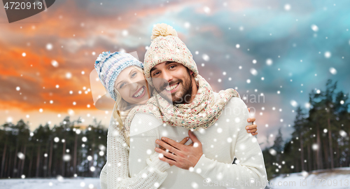 Image of smiling couple in winter clothes hugging