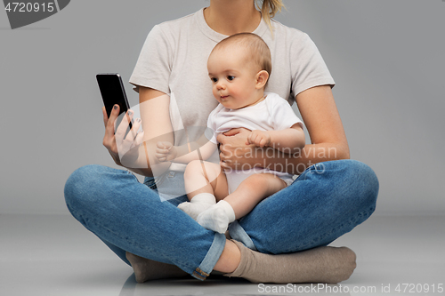 Image of mother and baby looking at smartphone