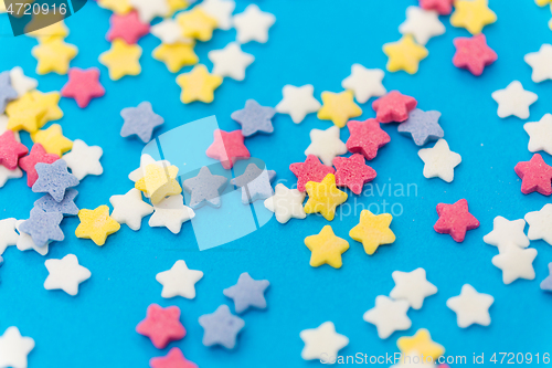 Image of star shaped pastry sprinkles on blue background