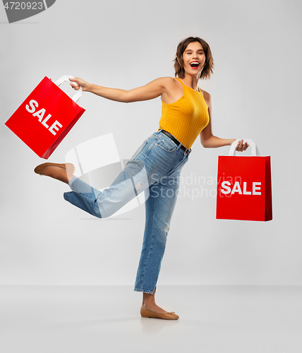 Image of happy smiling young woman with shopping bags