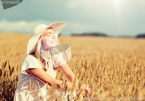 Image of happy young woman in sun hat on cereal field