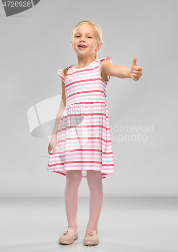 Image of beautiful smiling little girl showing thumbs up