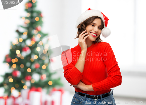 Image of happy young woman in santa hat on christmas