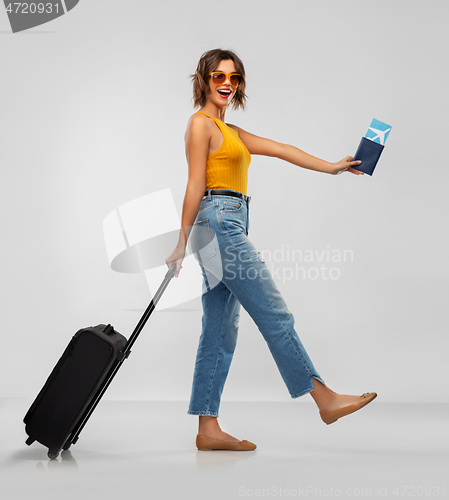 Image of happy young woman with air ticket and travel bag