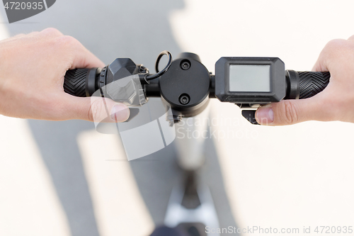 Image of close up of hands holding electric scooter wheel