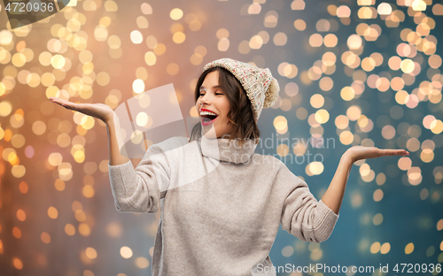 Image of young woman in winter hat holding something