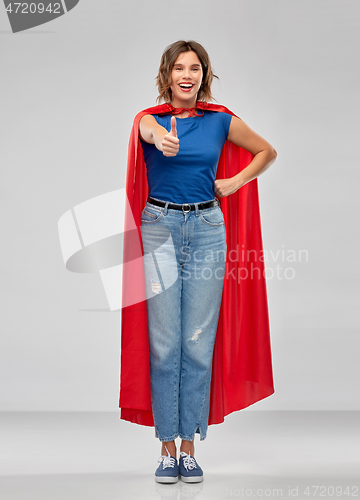 Image of happy woman in superhero cape showing thumbs up