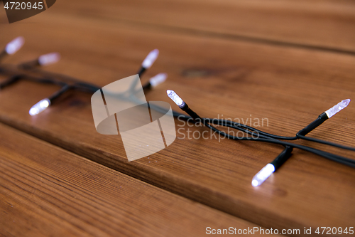 Image of christmas garland lights on wooden background