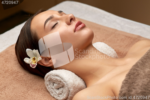 Image of young woman lying at spa or massage parlor