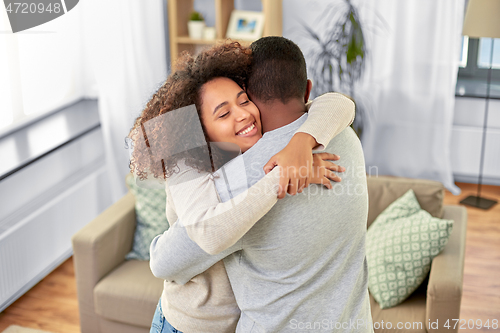 Image of happy african american couple hugging at home