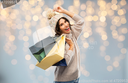 Image of young woman in winter hat with shopping bags