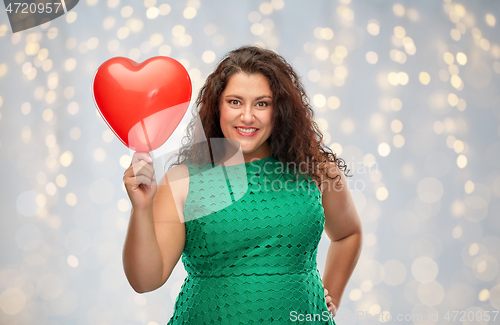 Image of happy woman holding red heart shaped balloon