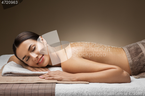 Image of woman lying with sea salt on skin at spa