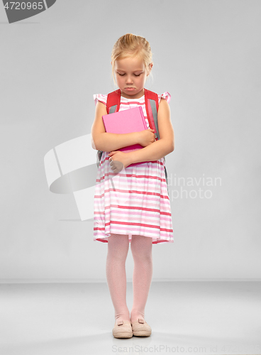 Image of sad little student girl with school bag and book