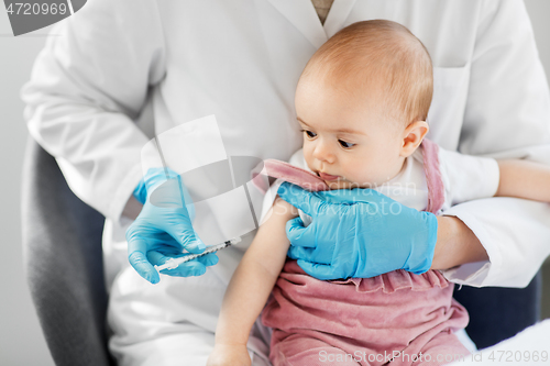 Image of doctor making vaccine for baby patient at clinic