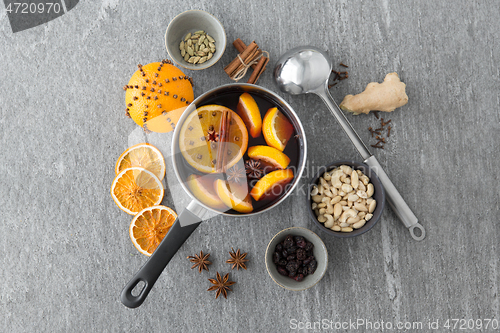 Image of pot with hot mulled wine, orange slices and spices