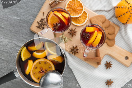 Image of pot with hot mulled wine, orange slices and spices