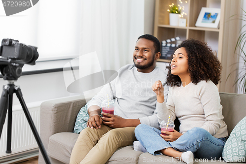 Image of couple of video bloggers with camera at home