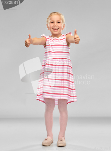 Image of beautiful little smiling girl showing thumbs up