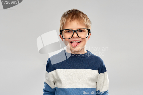 Image of portrait of little boy in glasses showing tongue