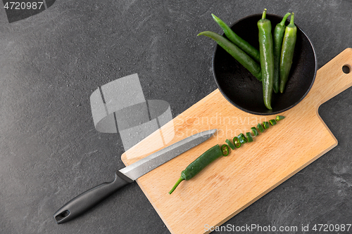 Image of green chili peppers and knife on cutting board