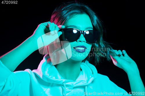 Image of woman wearing hoodie in neon lights over black