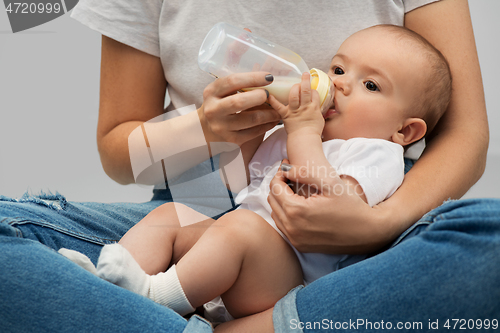 Image of close up of mother feeding baby with milk formula