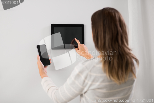 Image of woman using tablet computer and smartphone