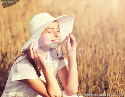 Image of happy young woman in sun hat on cereal field