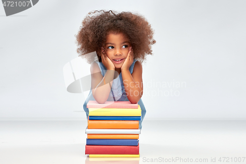 Image of smiling little african american girl with books