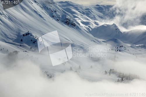 Image of Mountain winter landscape with fog and clouds