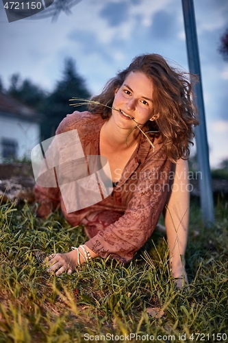 Image of Young woman posing at dusk