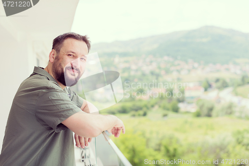 Image of man standing on a modern balcony