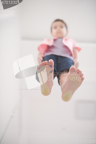 Image of little boy standing on transparent glass floor