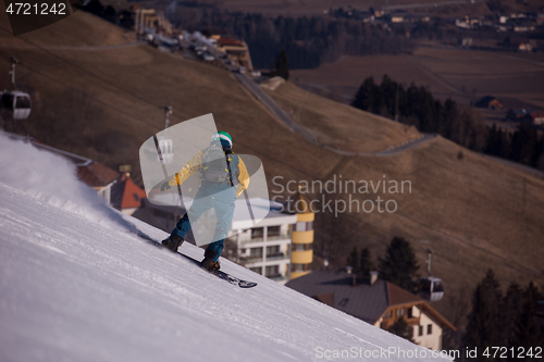 Image of snowboarder running down the slope and ride free style