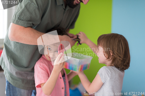 Image of sister and brother havin fun and play hairstylist game at home