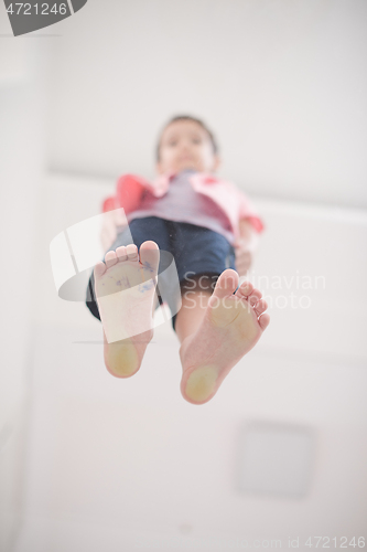 Image of little boy standing on transparent glass floor